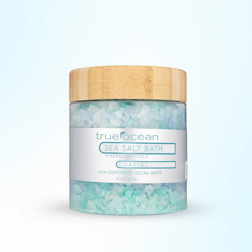 Jar of trueocean sea salt bath with a wooden lid on a light blue background