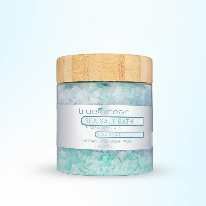 Jar of trueocean sea salt bath with a wooden lid on a light blue background